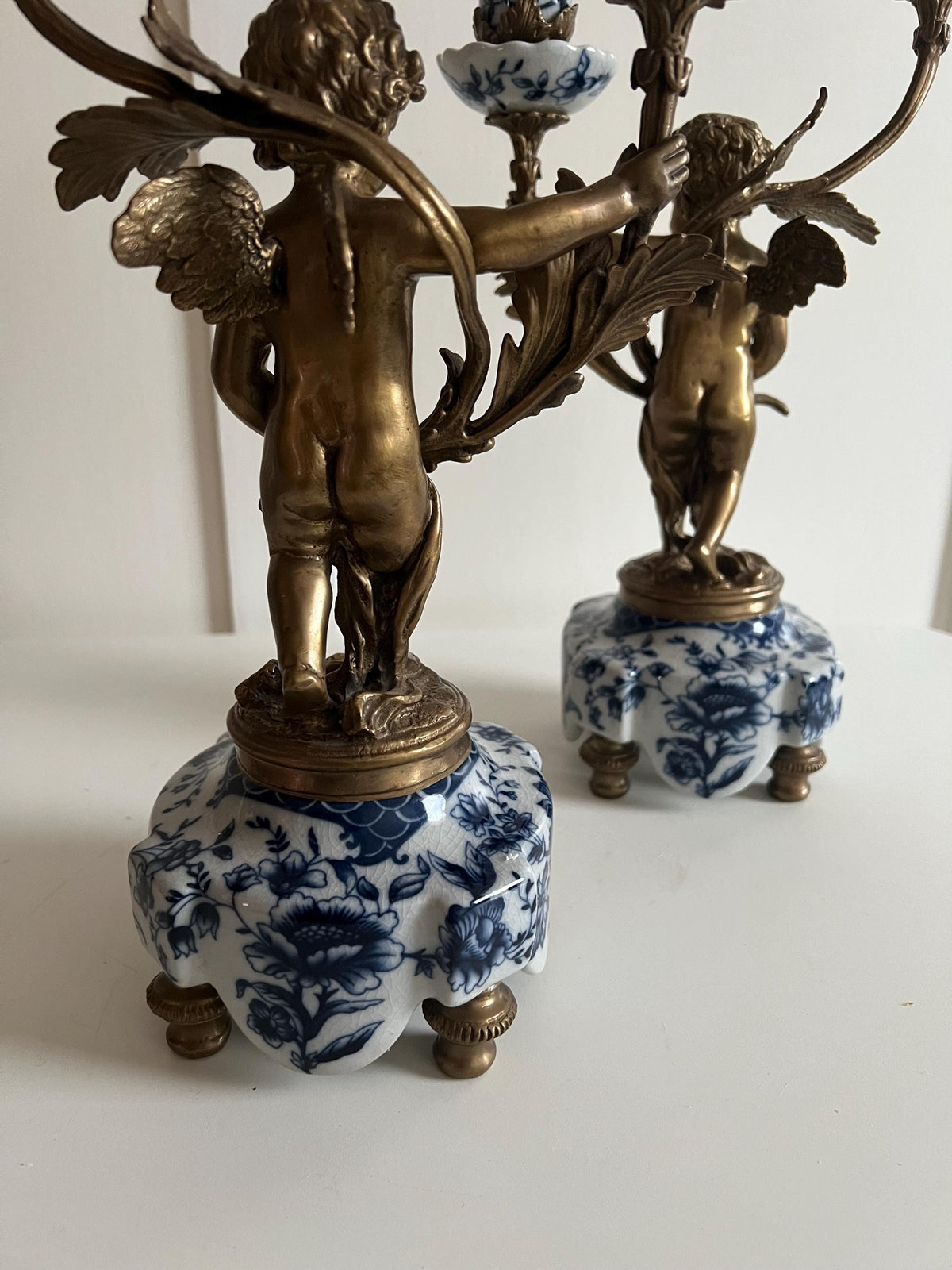 Ornate Cherub Candelabra Pair – Gilt Metal with Blue & White Porcelain Bases