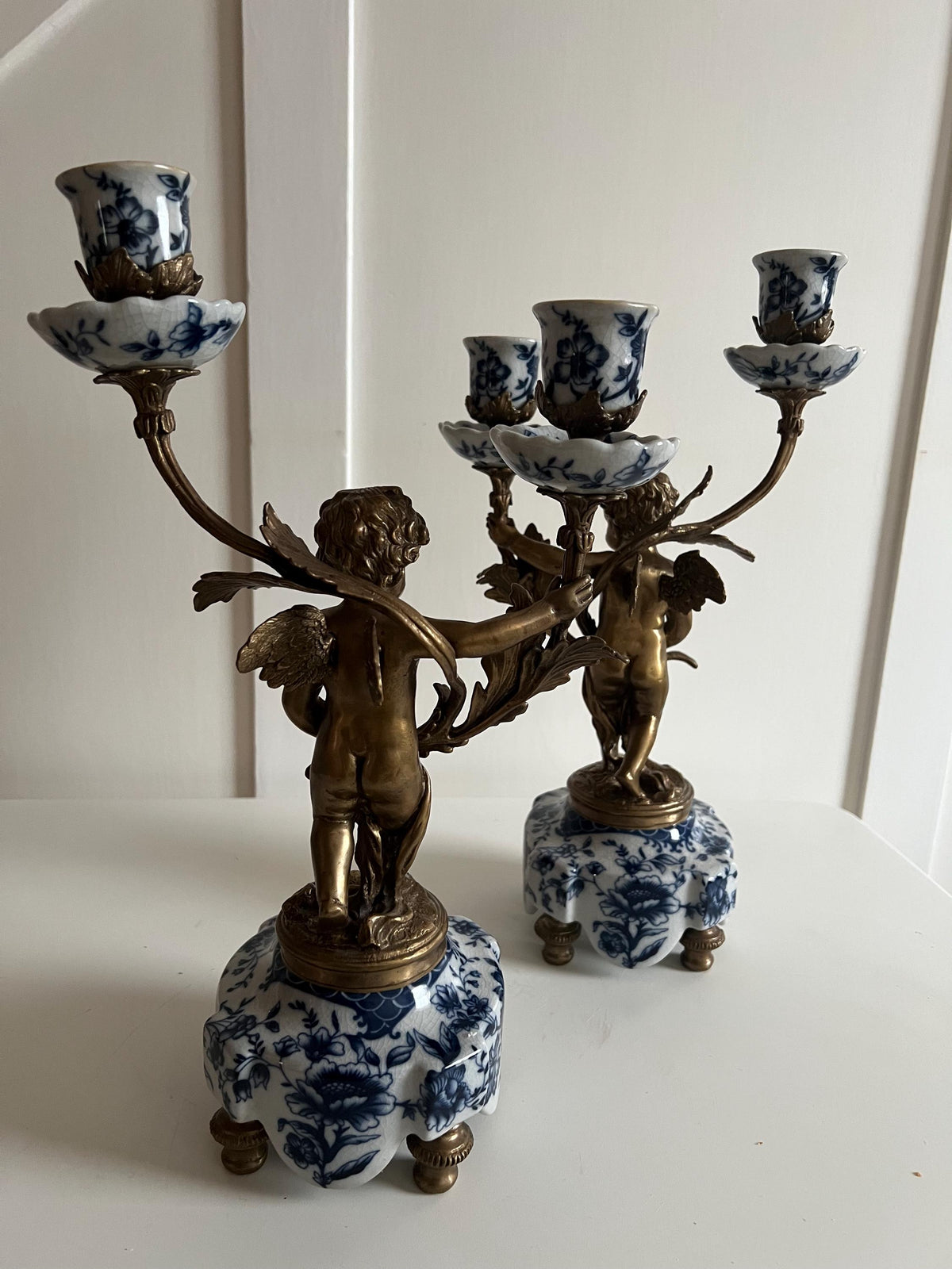 Ornate Cherub Candelabra Pair – Gilt Metal with Blue & White Porcelain Bases