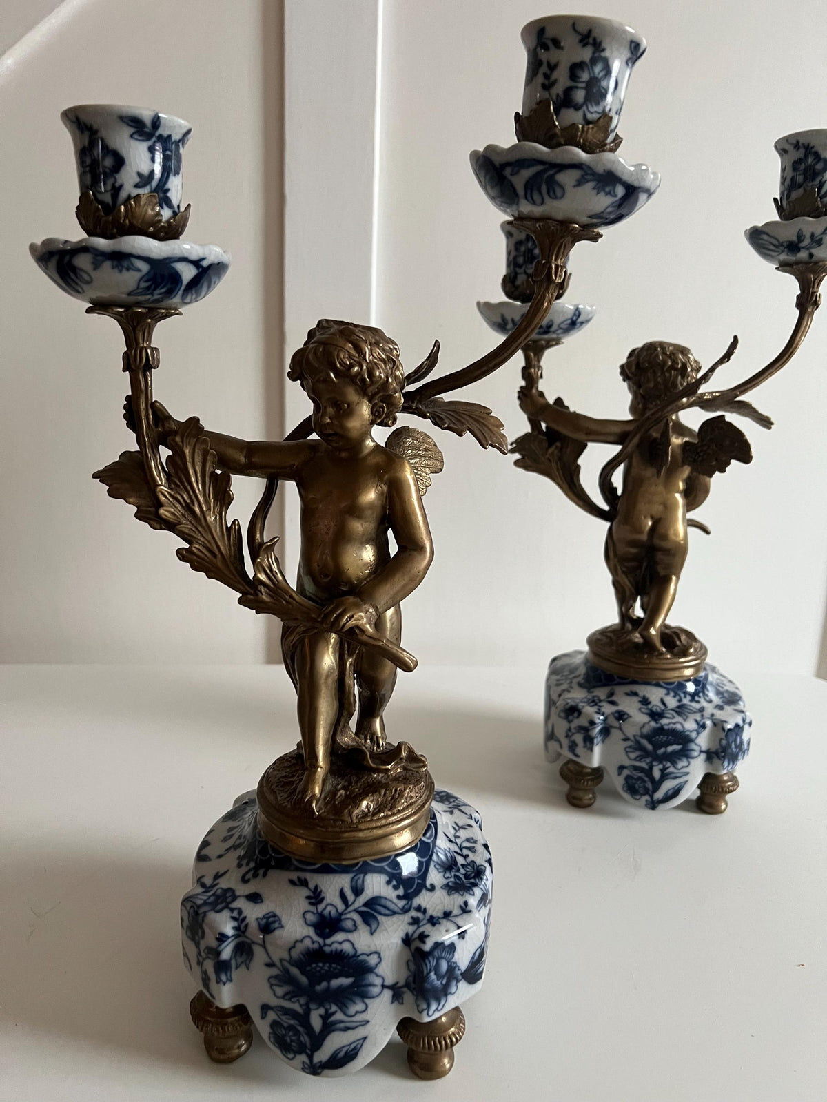 Ornate Cherub Candelabra Pair – Gilt Metal with Blue & White Porcelain Bases